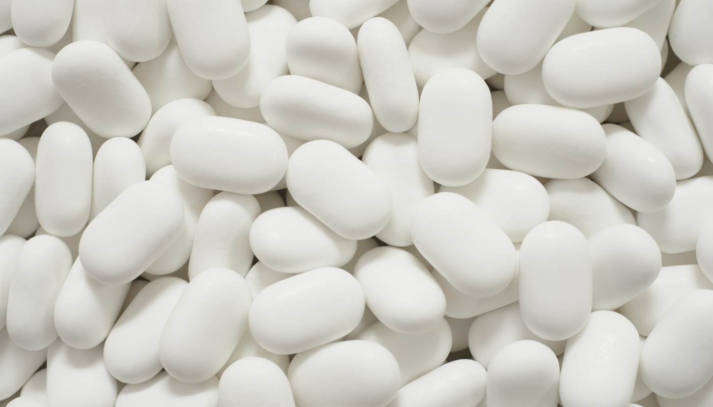 Assorted vitamin capsules and supplement bottles ready for a label check