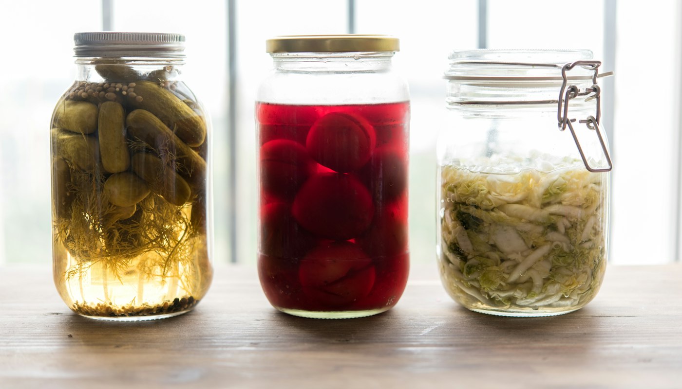 Jars of kimchi, sauerkraut and kefir, fermented foods that support a healthy gut microbiome