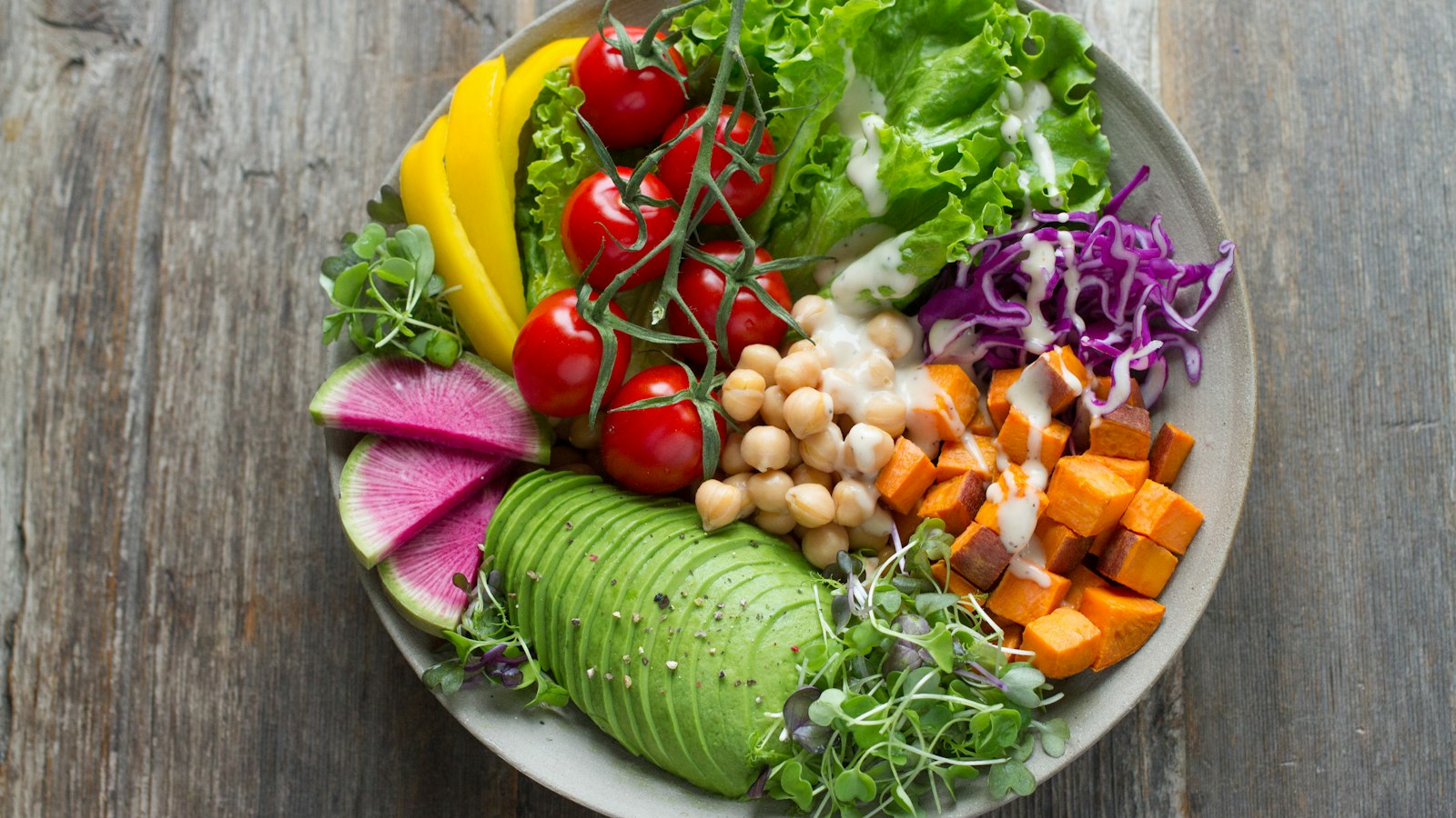 Colourful bowl of vegetables, beans and whole grains showing how to improve gut health with fibre and plant variety